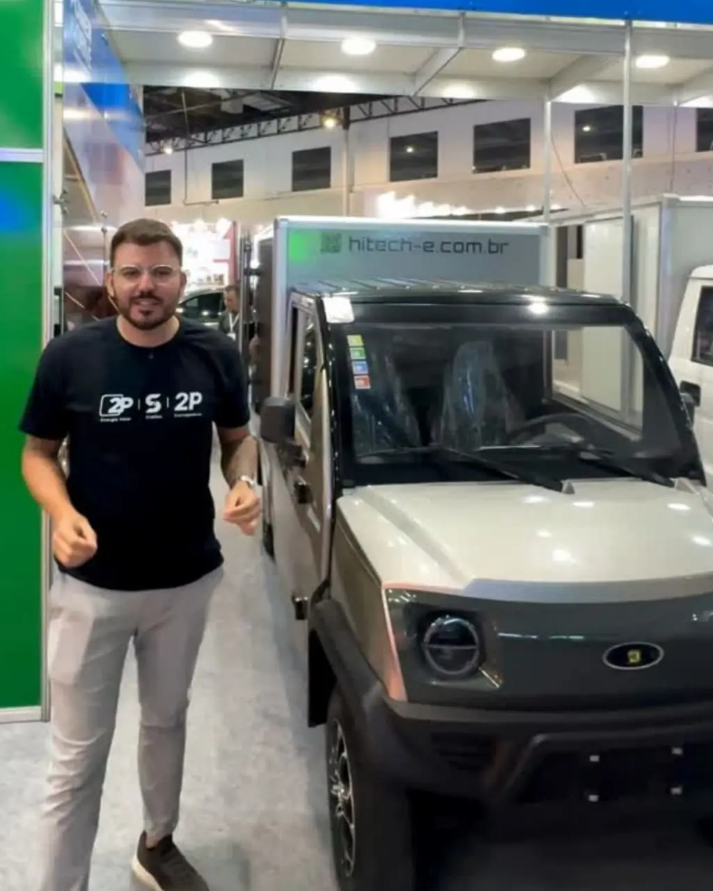 Representante da Plug Charge ao lado de um utilitário elétrico Hitech